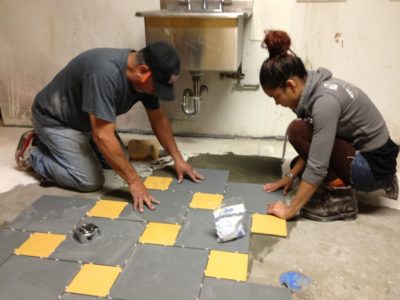 Students working on floor installation at the Bowery Mission.