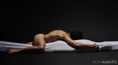 A nude male lies atop a completely shrouded figure