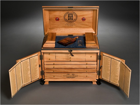 The tontine box, open displaying multiple drawers and bottle of Woodford Reserve at top