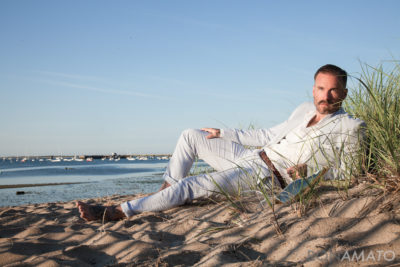 Gabe LaDuke wearing a suit lying on a sandy beach