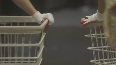 still from The Washing Society featuring a closeup of two laundry carts