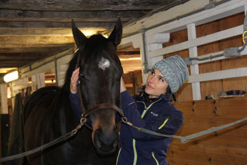 white woman in knit cap with horse