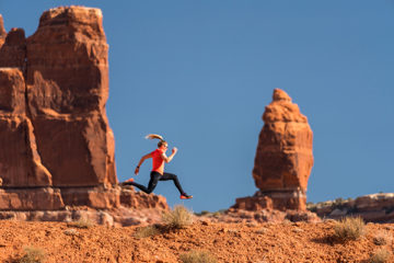 woman running among red rock formations