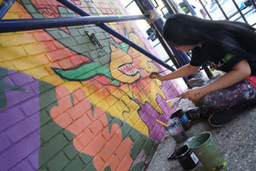 woman paints mural