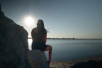 woman sitting in front of ocean