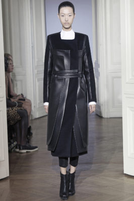 Model in midlength black leather coatdress