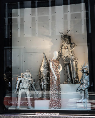 mannequin in sequin dresses with metal robot sculptures