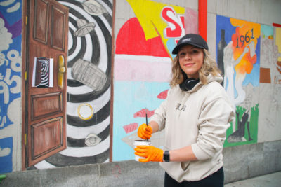 Young woman painting mural