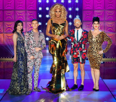 RuPaul in a gold dress and the judges on the main stage
