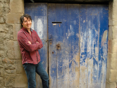 Man leaning against wall with wooden blue door
