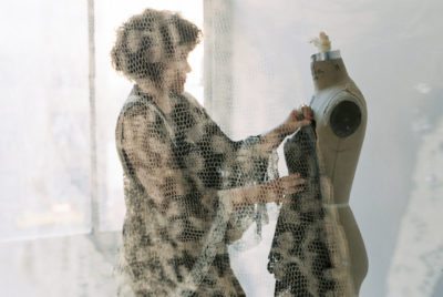Mimi Prober adjusting fabric on a dress form