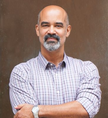 Tan bald man with goatee in button-down shirt