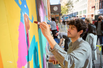 students working on a Chalk FIT mural on FIT's facade