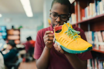 Boy embellishes yellow sneaker