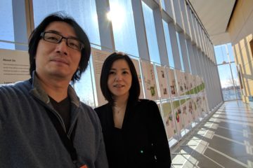 CJ Yeh and Christie Shin take a selfie in a brightly lit hallway
