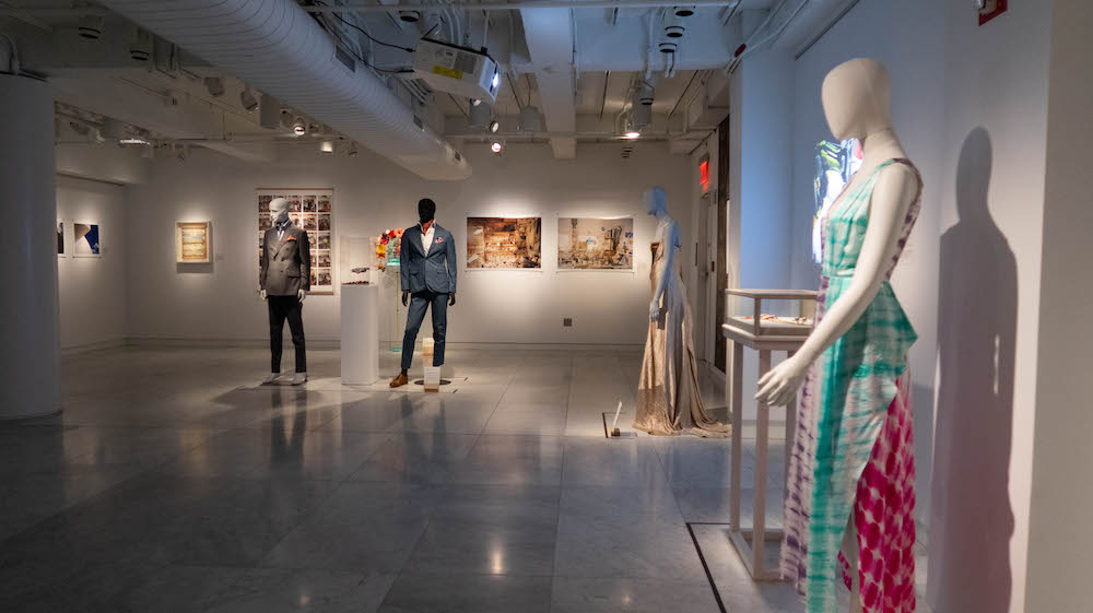 exhibition view of Creative Industry with three mannequins and framed artwork