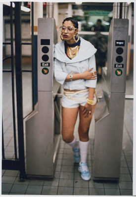woman standing at a New York City subway turnstile