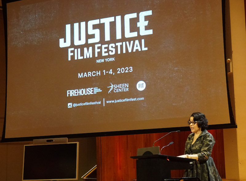 Nicole Finigan Ndzibah speaks at the podium of the Justice Film Festival
