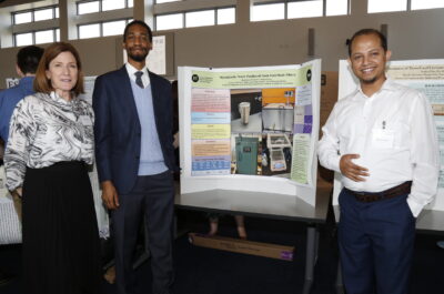 Three people in front of a scientific poster