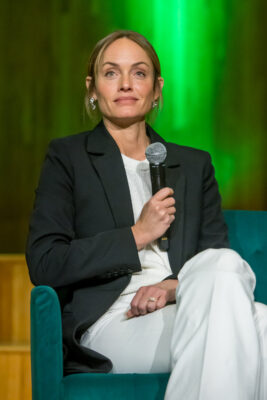 Amber Valletta holding a microphone sitting down