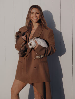 model in oversized jacket holding a rabbit