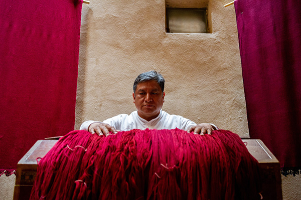 man standing behind a large red piece of cloth