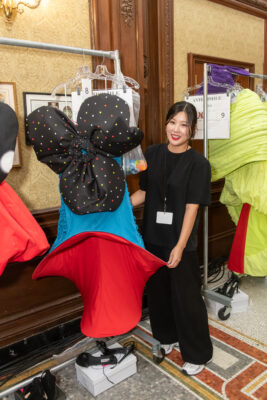 Hee Jin Hwang standing with one of her garments on a hook
