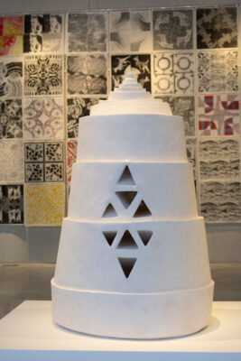 white hive-like tower sculpture with diamond cutouts that see through the shave