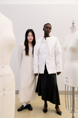 Emily Cha, Fashion Design BFA '24, stands with a model wearing her garment