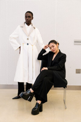 Nadia Phie, Fashion Design BFA '25, sits on a chair while a model wears her garment