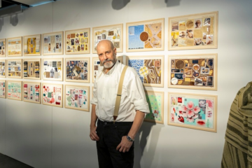 Italian man in suspenders standing in front of a wall of mood boards