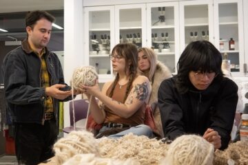Students feeling mohair yarn in a laboratory setting