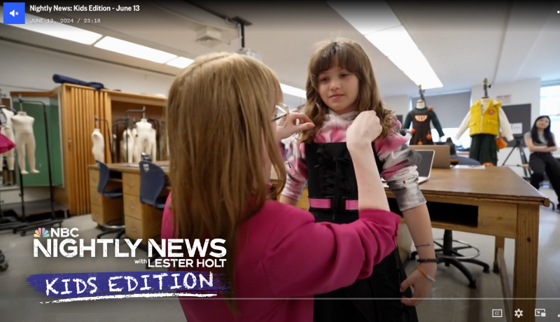 screenshot of video with children's wear design student adjusting garment on NBC kids correspondent in FIT classroom; NBC Nightly News Kids Edition logo