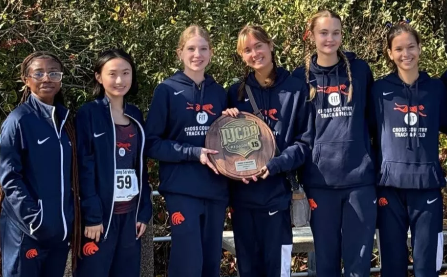 student athletes from the women's cross country team hold their trophy