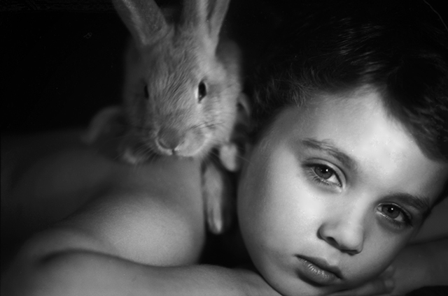 Portrait of a child with his pet rabbit.