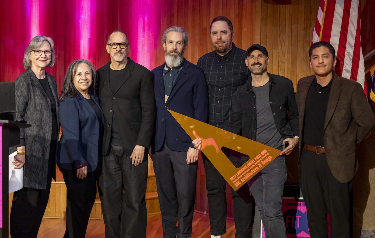 members of INC Architecture, FIT Interior Design faculty, and an FIT student stand on stage at Katie Murphy Amphitheatre; a member of the architecture firm holds the Lawrence Israel Prize which is an orange triangle