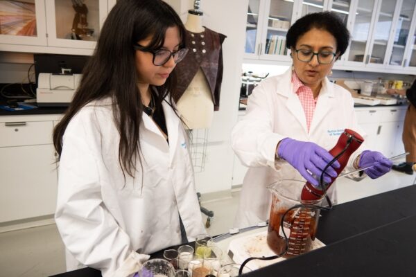 Professor and student creating a redding material in a beaker