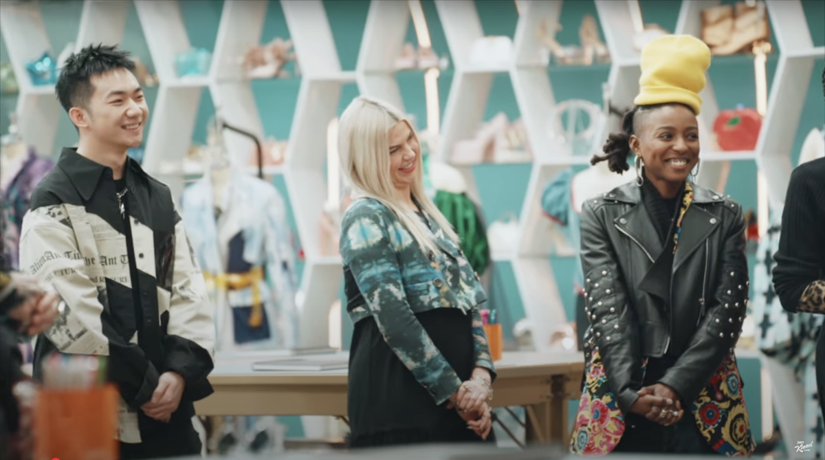 three people stand looking at someone smiling