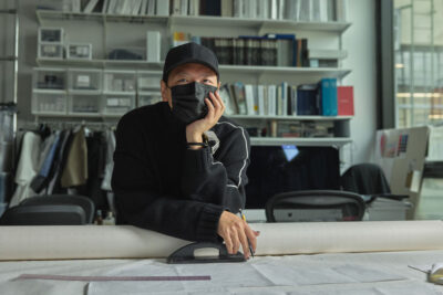 Peter Do in his design office leaning his chin on his hand on his desk