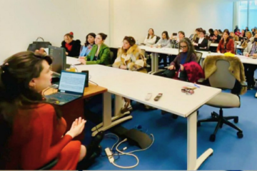 Mallorie Dunn presents to an audience at rows of tables