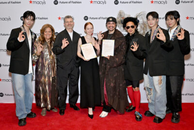 Jiseok, Fern Mallis, President Jason Schupbach, Julia Endecott, Andres Guerra, Andy Chia Yu, PJ, and Chanyeon pose in front of a step and repeat