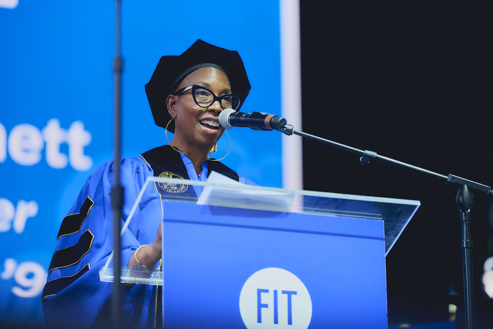 Malene Djenaba Barnett in regalia at the FIT commencement lecturn.