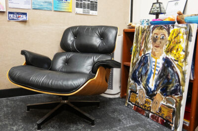 Black Eames Lounger beside a painting by Rebecca Hoffman, in Hoffman's FIT Counseling Center office.
