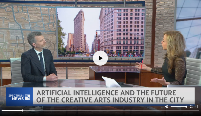 In a screenshot of a video clip, Jason Schupbach sits across from a female NY1 host who is gesturing to him
