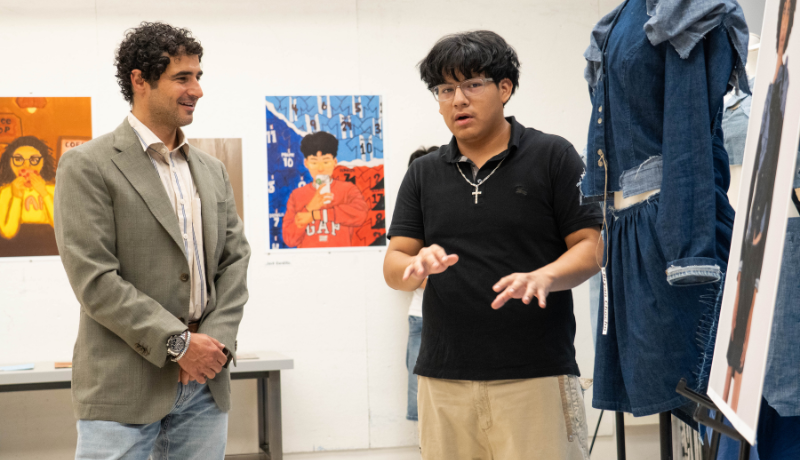 A Precollege student discusses his garment with Zac Posen