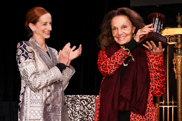 Vanessa Friedman applauds Diane von Furstenberg as she holds the MFIT prize—a large brass spool of thread—up in the air